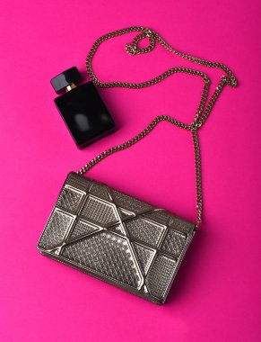 Metalik zinciri parfüm yakınındaki küçük kadının metalize gümüş çanta