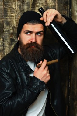 Sakallı, Kafkas hippisi elinde şişe, puro içiyor.