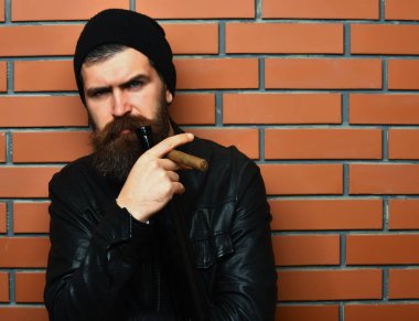 Sakallı, Kafkas hippisi elinde şişe, puro içiyor.