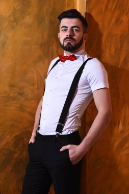 Stüdyo duvarında ciddi bir yüzü olan sakallı bir adam.