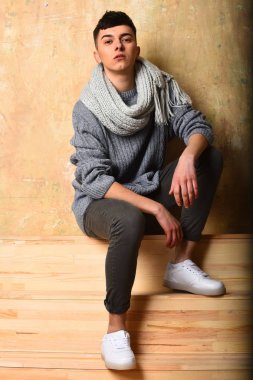 Gri süveter ve eşarplı yakışıklı genç adam.