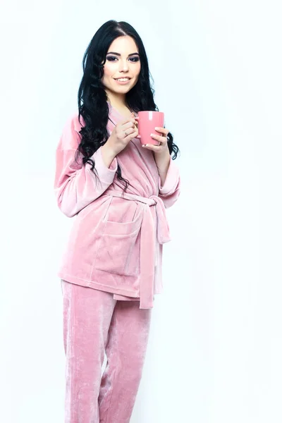 Lachend meisje in roze velours pyjama home suit met beker — Stockfoto