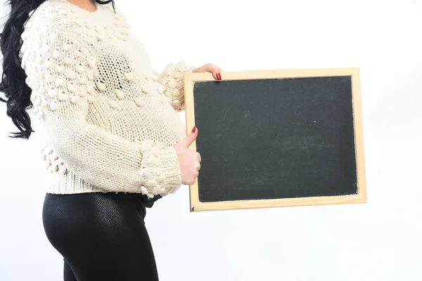 Mãos femininas de mulher grávida segurando placa preta — Fotografia de Stock