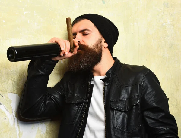 Sakallı, Kafkas hippisi elinde şişe, puro içiyor.