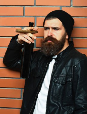 Sakallı, Kafkas hippisi elinde şişe, puro içiyor.