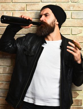 Sakallı, Kafkas hippisi elinde şişe, puro içiyor.