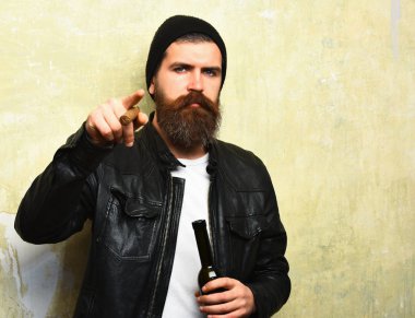 Sakallı, Kafkas hippisi elinde şişe, puro içiyor.