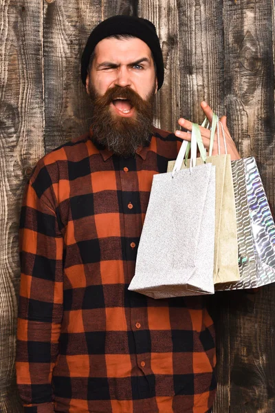 Bärtiger brutaler kaukasischer Hipster mit Schnurrbart hält Einkaufspakete in der Hand — Stockfoto