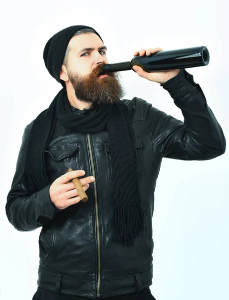Barbudo brutal bebida hipster caucasiano de garrafa e fumar charuto — Fotografia de Stock