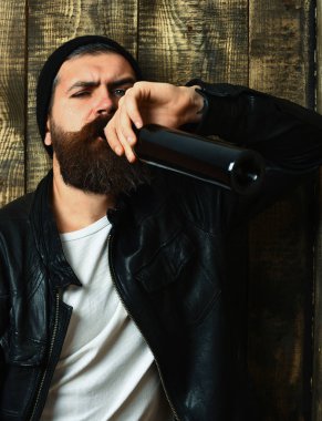 Sakallı vahşi beyaz hippi şişeden içiyor.