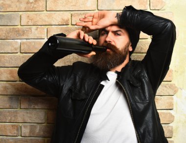 Sakallı, Kafkas hippisi elinde şişe, puro içiyor.