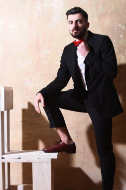 Stüdyo duvarında ciddi bir yüzü olan sakallı bir adam.