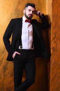 Stüdyo duvarında ciddi bir yüzü olan sakallı bir adam.