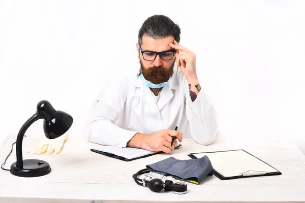 Médico caucásico barbudo sentado en la mesa — Foto de Stock