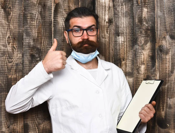 Bearded brutal caucasian doctor or postgraduate student with clipboard