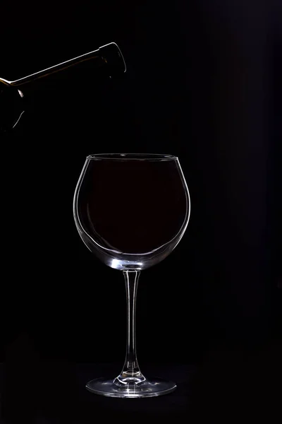 Vinho e garrafa vazios com vinho isolado sobre fundo preto — Fotografia de Stock