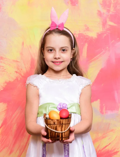 Маленькая счастливая девочка держит ведро с пасхальными яйцами — стоковое фото