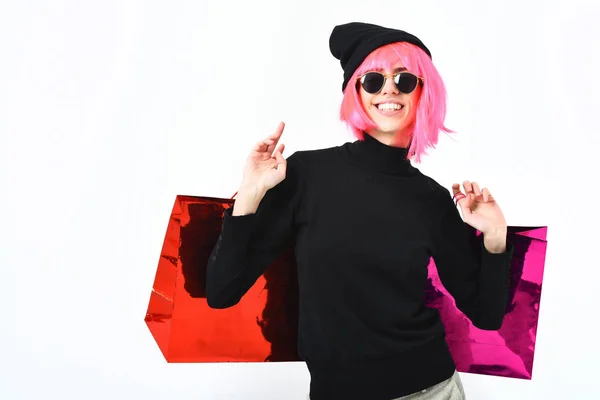 Fashionabla sexig tjej i rosa peruk innehav paket eller väskor — Stockfoto