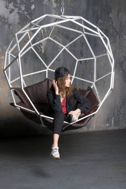 geometrik sandalyede şapkalı güzel kadın