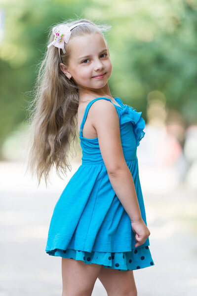 small baby girl with smiling face in blue dress outdoor