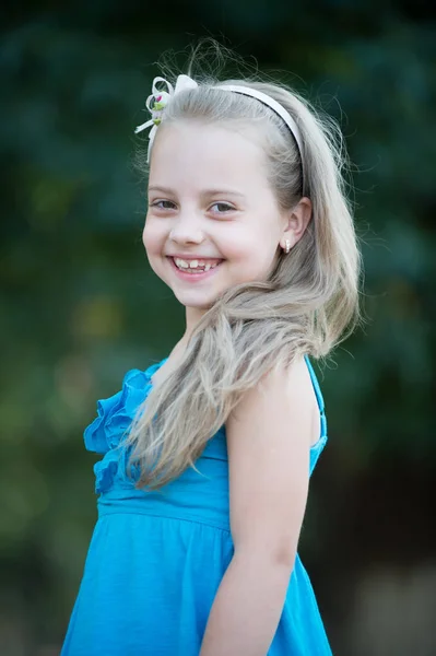 Malé děvčátko s usměvavou tvář v modrých šatech venkovní — Stock fotografie
