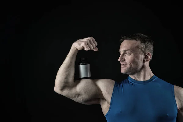 Knappe bodybuilder man met gespierd lichaam houdt pot van de pil, steroïden — Stockfoto