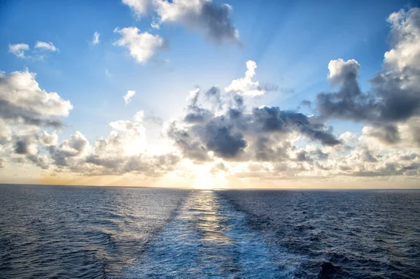 Водна стежка, що піниться за човном під час заходу сонця або сходу сонця — стокове фото