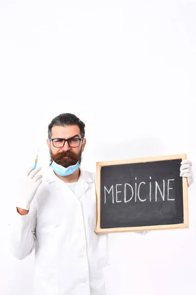 Dokter berjenggot kaukasia memegang jarum suntik dan papan dengan prasasti Obat — Stok Foto