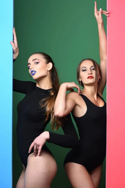 Dos chicas guapas con labios rojos y azules en trajes —  Fotos de Stock