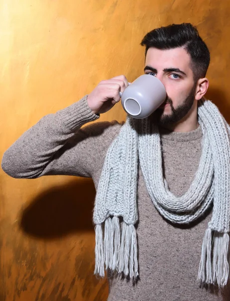 bearded man drinking tea, coffee from cup with serious face