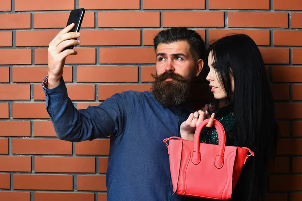 Barbudo hombre y bastante sexy mujer con bolsa y teléfono — Foto de Stock