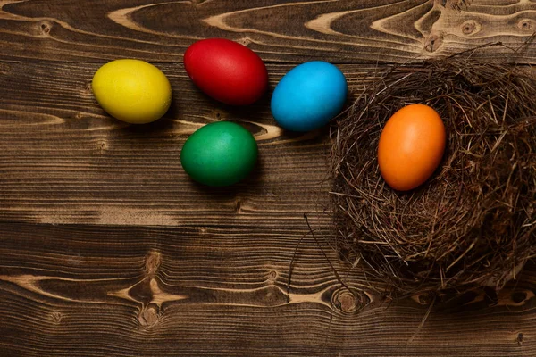 Huevos coloridos dentro del nido. Feliz concepto de Pascua —  Fotos de Stock