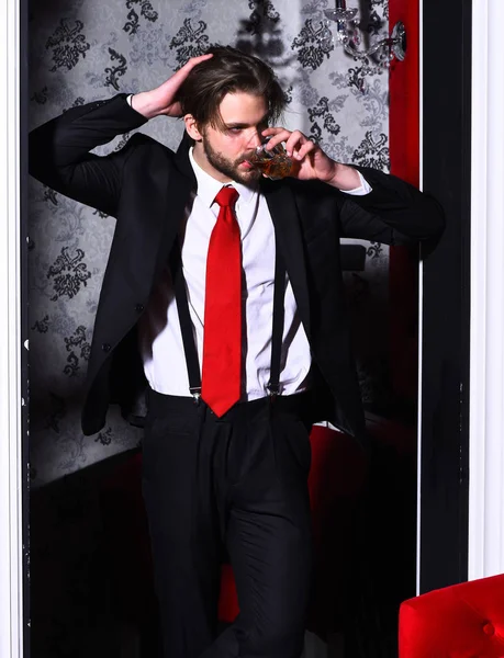 Бородатий чоловік, бізнесмен у костюмі, червона краватка тримає віскі скло — стокове фото