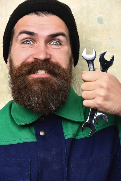 Vousatý brutální bělošský mechanik držící kovové klíče — Stock fotografie