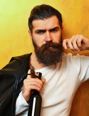 Sakallı, Kafkas hippisi elinde şişe, puro içiyor.