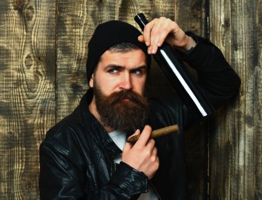 Sakallı, Kafkas hippisi elinde şişe, puro içiyor.