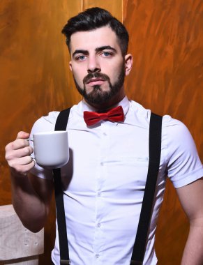 Elinde çay tutan sakallı adam, ciddi yüzlü kahve.