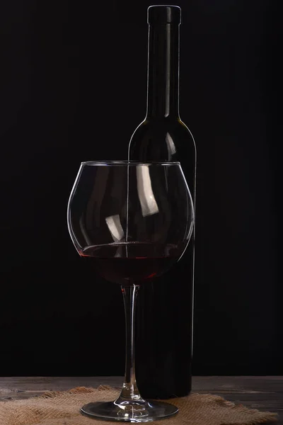 Copa de vino con botella sobre mesa de madera con servilleta de saco —  Fotos de Stock