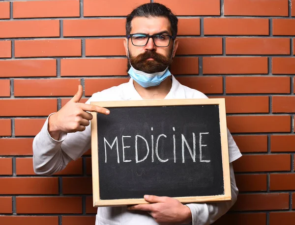 Бородатий жорстокий кавказький лікар тримає дошку з написом "Медицина" — стокове фото