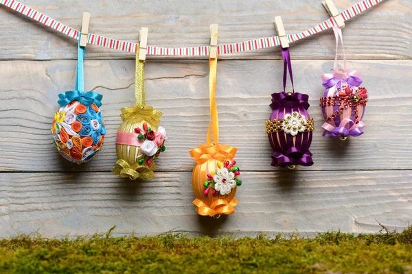 Easter colorful eggs decorated with thread, beads hanging on clothespin — Stock Photo, Image