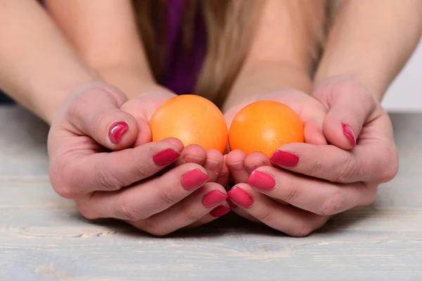 hands of mother and daughter holding orange handmade eggs