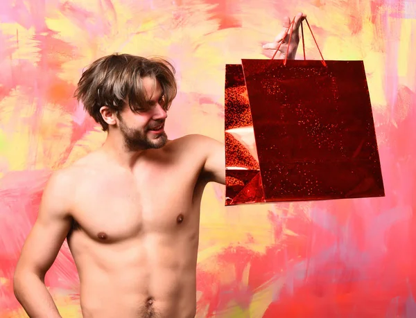 Caucásico barbudo sexy macho hombre celebración rojo paquete o bolsa — Foto de Stock