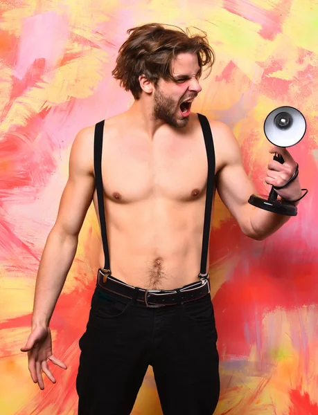 Blanke bebaarde macho man in broek met bretels holding lamp — Stockfoto