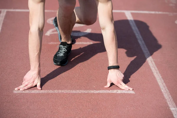 Man runner with muscular hands, legs start on running track — Stock Photo, Image