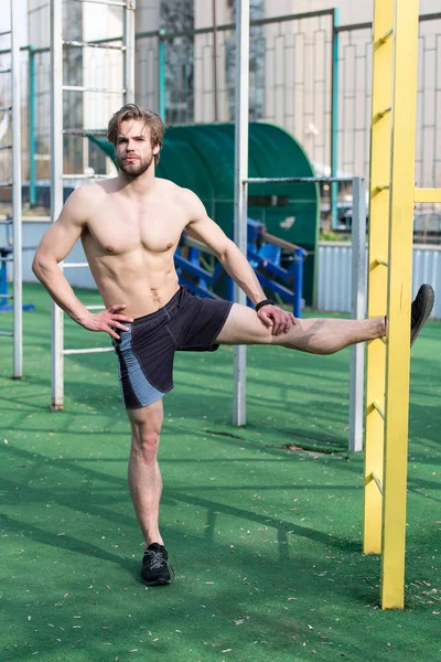 Athletic Brodaty mężczyzna z mięśni ciała, rozciągający się na zewnątrz stadionu — Zdjęcie stockowe