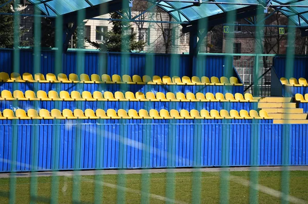 Vacío amarillo y azul estadio de fútbol tribuna detrás de valla — Foto de Stock