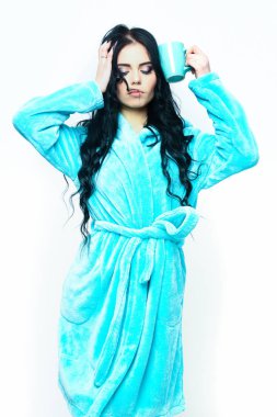 Turkuaz kadife bornozla fincanla poz veren seksi kız.