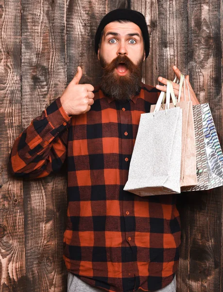 Barbudo brutal caucasiano hipster com bigode segurando pacotes de compras — Fotografia de Stock