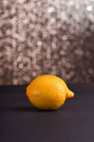 Citron på grå bord, glittrande bakgrund — Stockfoto