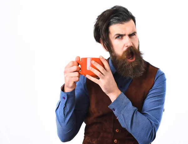 Бородатый мужчина держит чашку с кофе, чай с сердитым лицом — стоковое фото